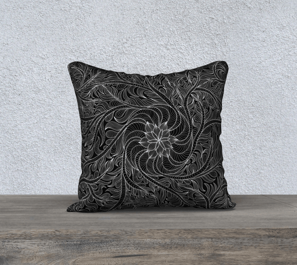 Square pillow with intricate white design on black background.
